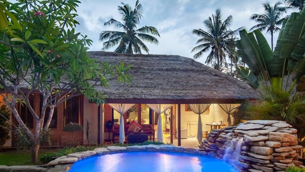A resort with a pool, a thatched-roof structure, and tropical vegetation. - Dolcemare Resort (Gili Air)