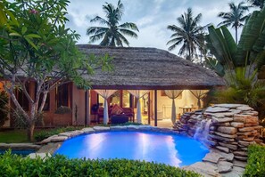 A resort with a pool, a thatched-roof structure, and tropical vegetation. - Dolcemare Resort (Gili Air)