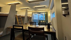 A modern room with a dining table, chairs, a sofa, and a TV. - Tsuboniwa apartment UTSUBO (Osaka)
