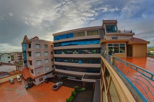 A multi-story building with a modern architectural design, featuring balconies and large windows.