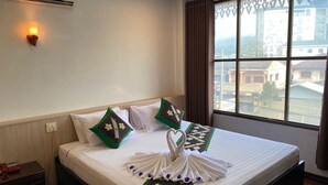 A hotel room with a bed, a bedside telephone, a wall-mounted air conditioner, and a window with curtains. - Anoulackkhenlao Hotel (Phonsavan)