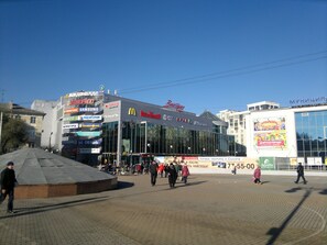 Ein Geschäftsgebäude mit mehreren Schaufenstern, darunter ein McDonald's und ein Samsung-Geschäft.