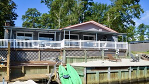 A waterfront house with a covered deck and a dock. - The Grey Goose (Waterfront) Historic New Bern - Private Beach - BRING YOUR BOAT! (New Bern)