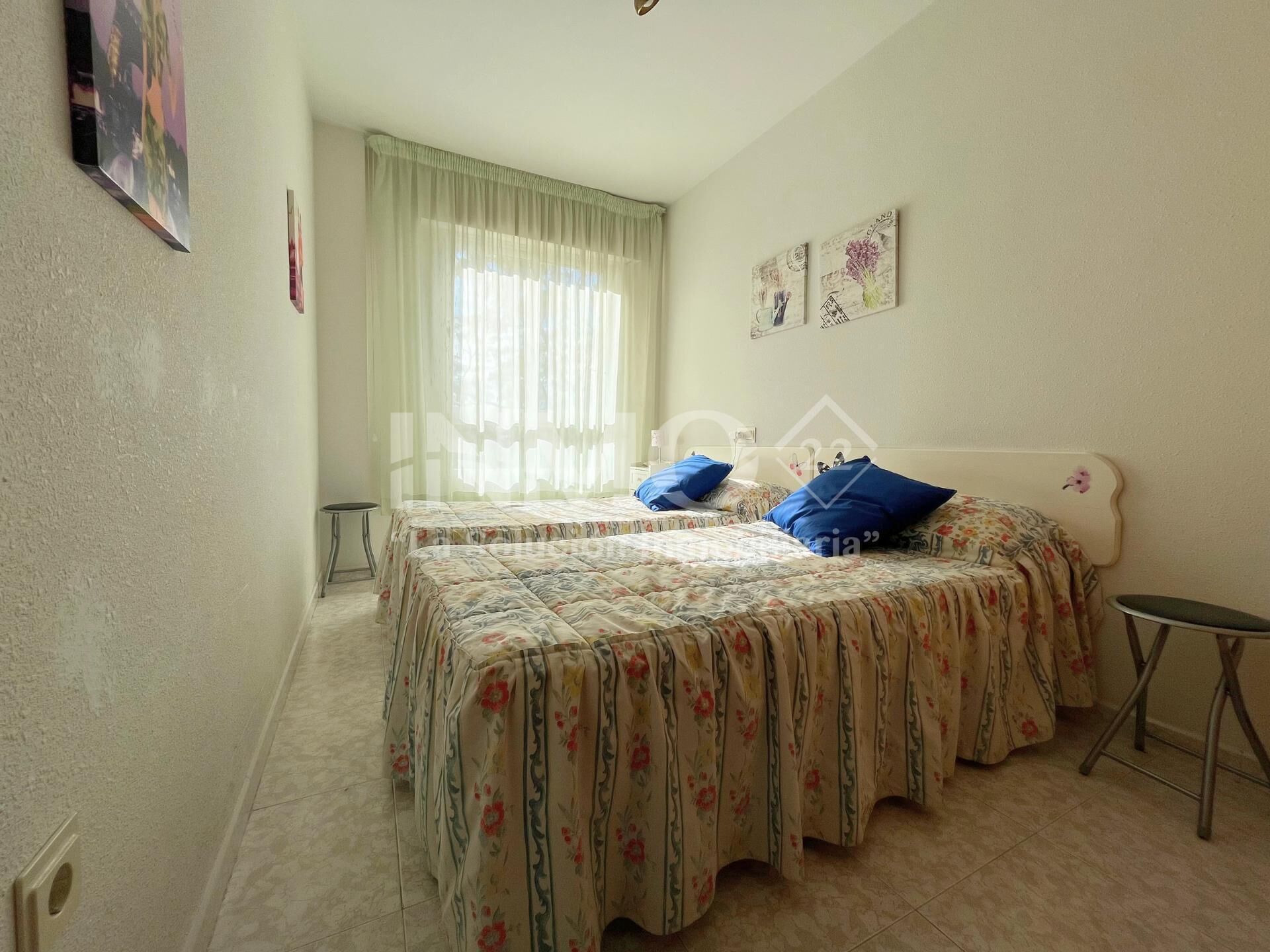 2 dormitorios y tabla de planchar con plancha