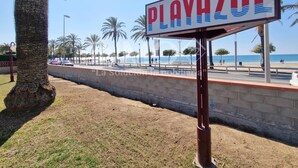 A beachside sign with the name "PLAYAZULI" and a palm tree in the foreground.