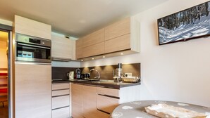 A modern kitchen with a built-in oven, microwave, and coffee maker. - Cozy studio 4 pers, ski-in/ski-out, terrace, garage, WIFI (La Clusaz)