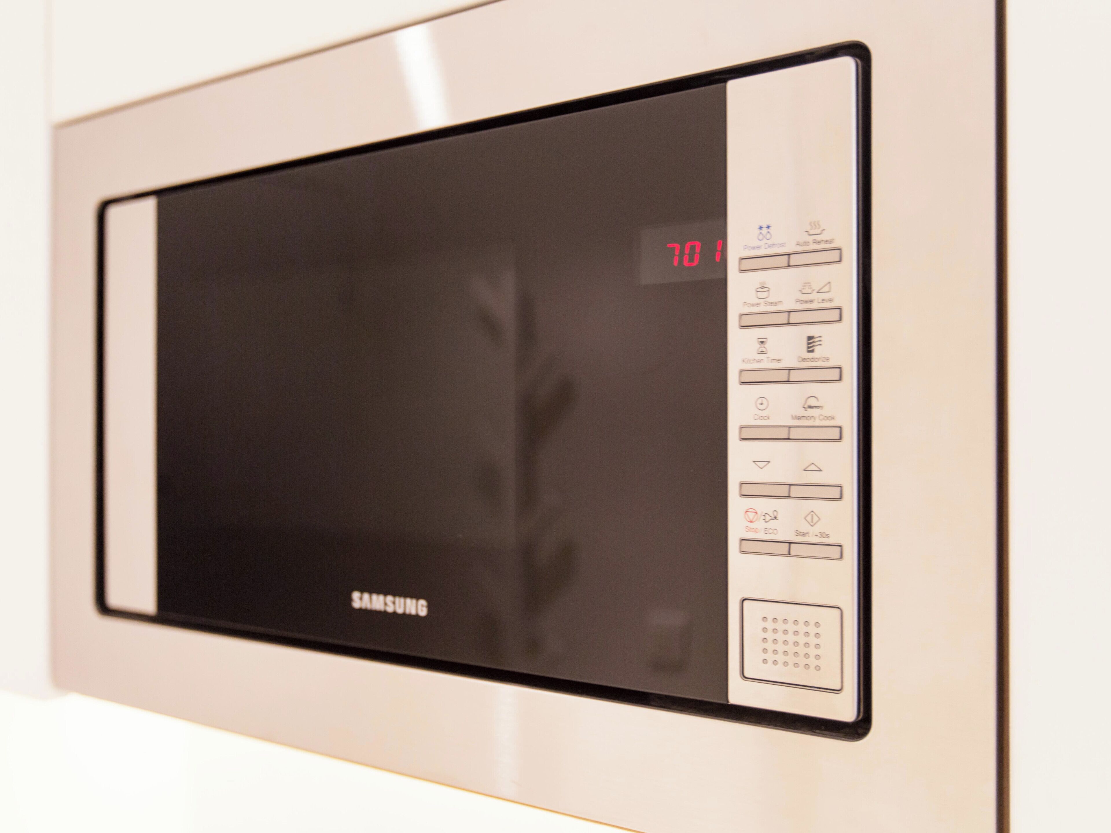 A Samsung microwave with a digital display and various control buttons.