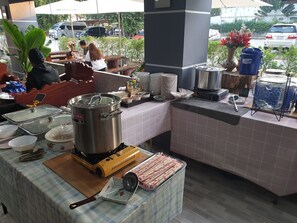 A buffet setup with various food items and cooking equipment. - Ban Kaeng Resort (Chiang Khan)