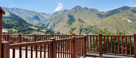 A wooden deck with a view of mountains.
