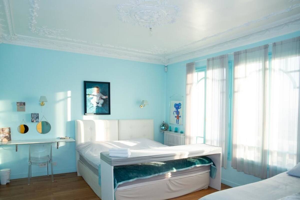 A bedroom with a bed, a desk, and a chair.