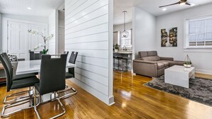 A modern living room with a dining area, a ceiling fan, and a kitchen in the background. - 15% OFF Monthly | 10% OFF Weekly-Urban Oasis 4BD House close to FQ & City Hot Spots (New Orleans)