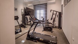 A home gym with a treadmill, stationary bike, and weight bench. - 1920s Boutique Hotel and Restaurants (Cairo)