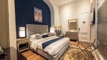 A hotel room with a bed, bedside lamps, a nightstand, a chair, a dresser, a mirror, and a door with a room number.