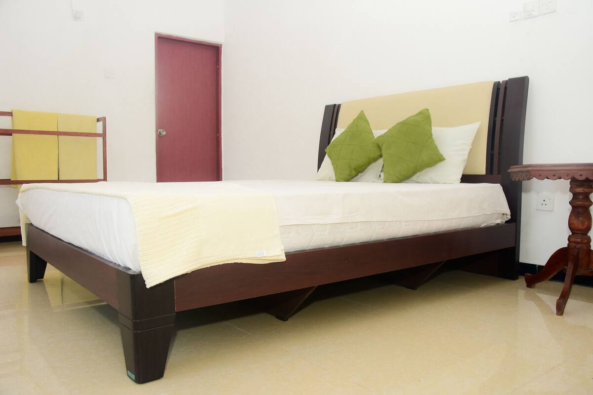 A bed with a wooden frame, a white mattress, and two pillows.