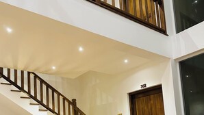 A staircase with wooden railings, a wooden door with the number 302, and a beige sofa. - Kings Landing Unawatuna (Unawatuna)