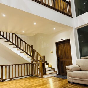 A staircase with wooden railings, a wooden door with the number 302, and a beige sofa. - Kings Landing Unawatuna (Unawatuna)