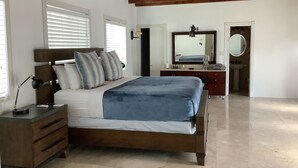 A bedroom with a wooden bed, bedside tables, a dresser, a mirror, and a ceiling fan. - House - Miami pool house, near Miami Int Airport and attractions. (Miami Springs)