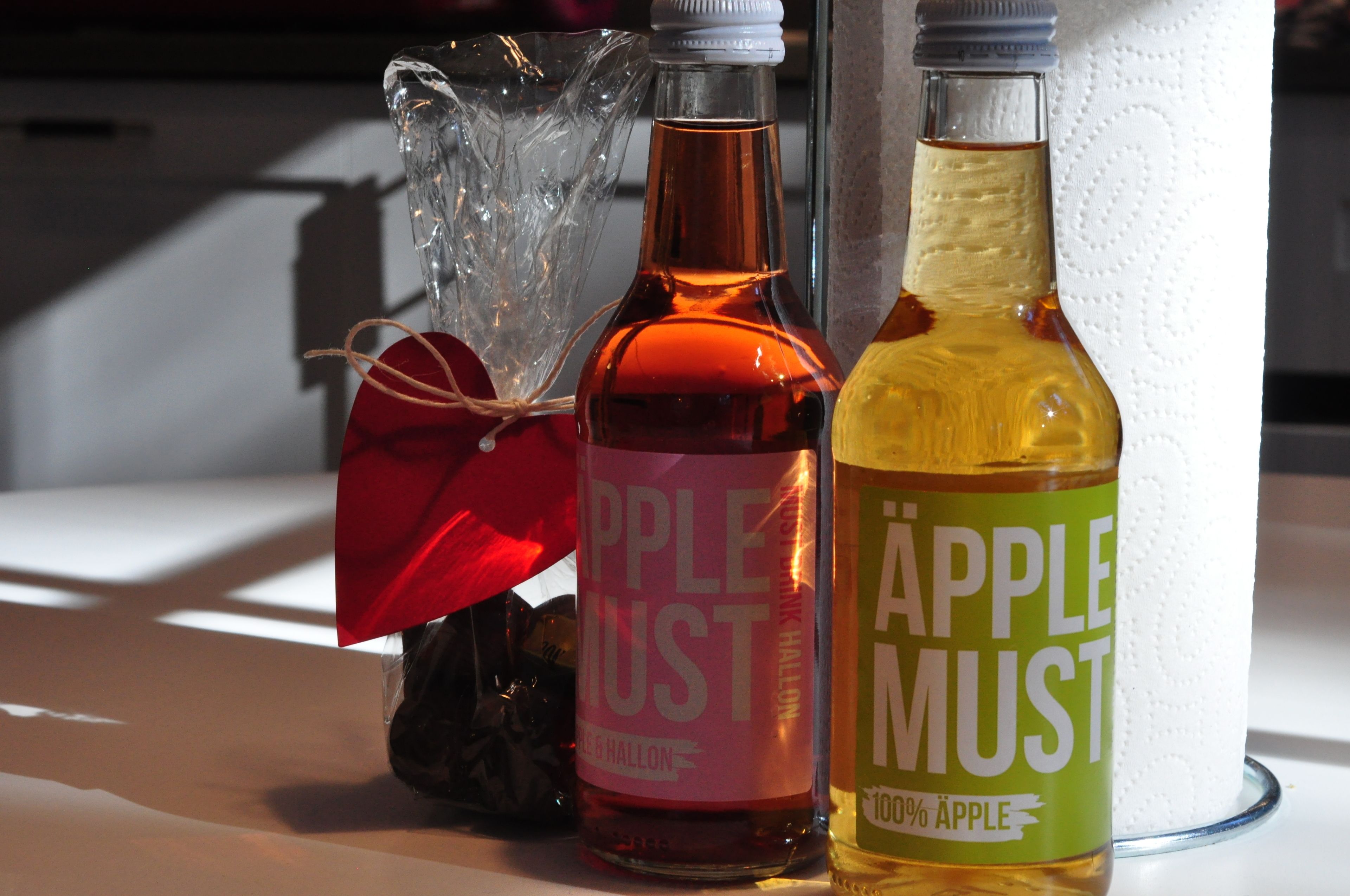 Three bottles of apple products on a table.