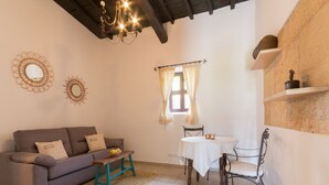 A cozy living room with a sofa, a small table, and a dining table. - Typical Ibizan country house with private pool in a beautiful protected environment! (ISLAS BALEARES)