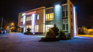 A modern hotel with a sign reading "kardamon" and a paved entrance area. - Hotel Kardamon (Tarnow)