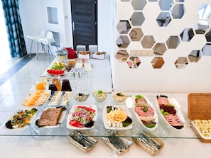 Una mesa de bufé con diversos alimentos y utensilios.