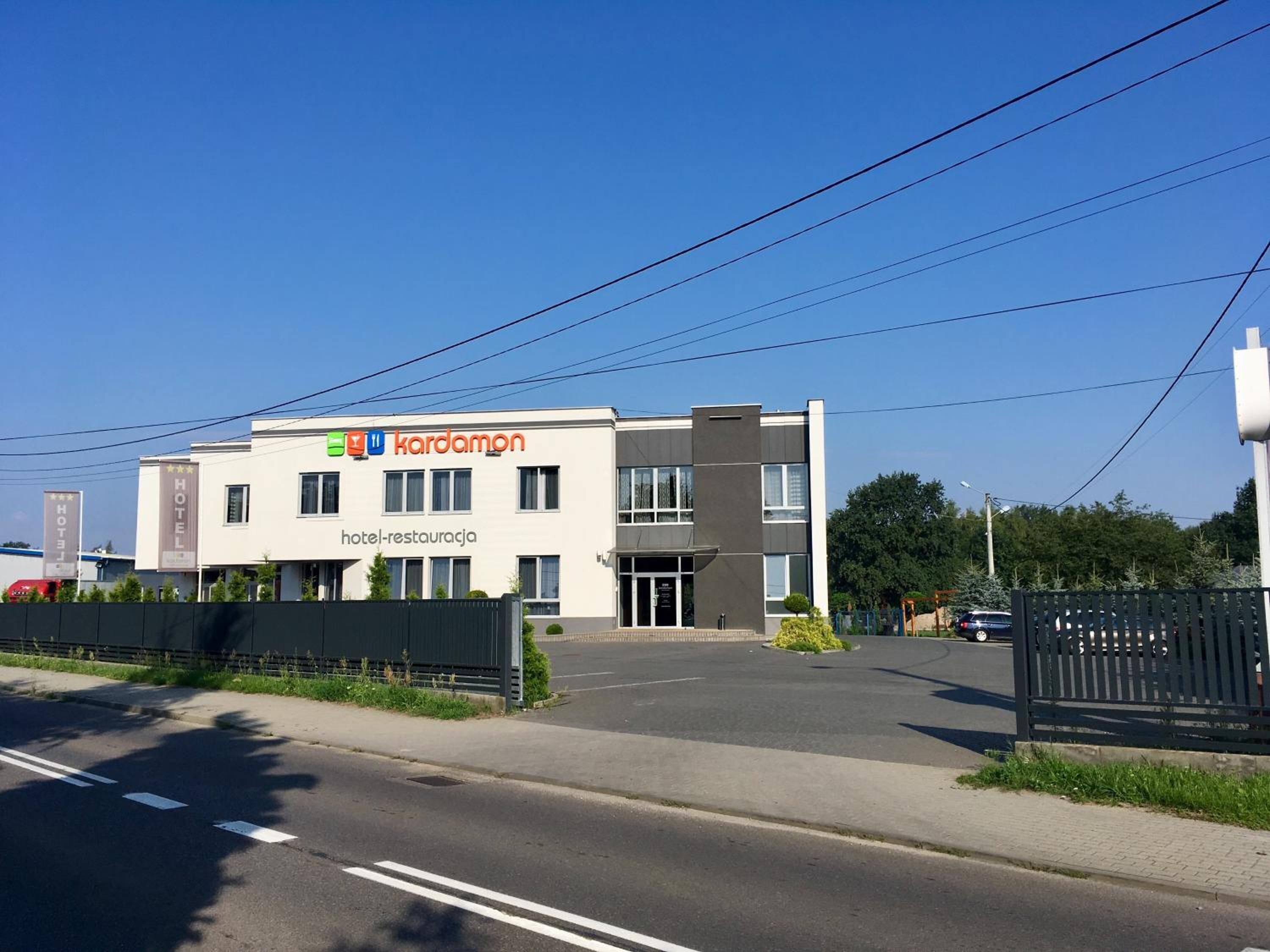 A modern hotel building with a sign reading "Kardamon hotel-restauracja".