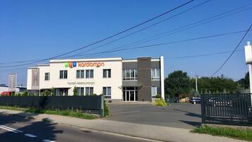 A modern hotel building with a sign reading "Kardamon hotel-restauracja".