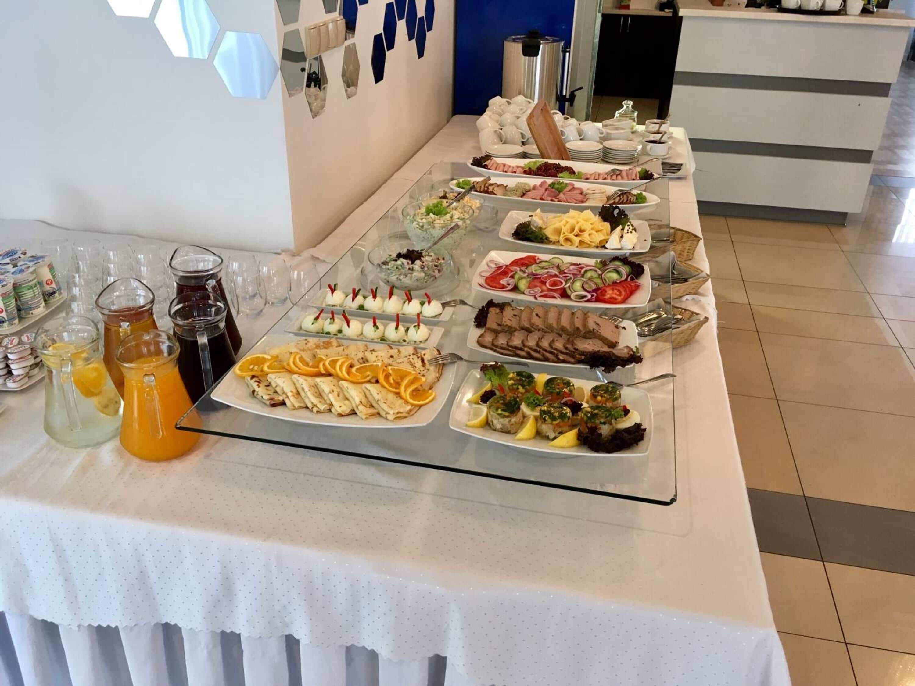 A buffet table with various food items and beverages.
