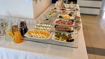 A buffet table with various food items and beverages.