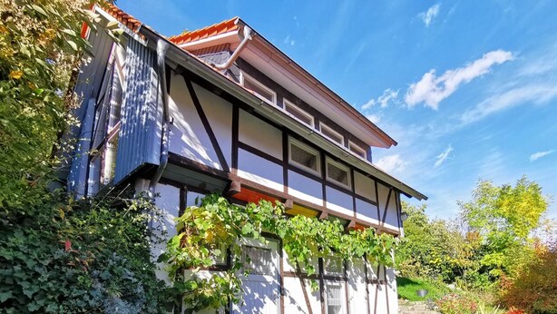 A traditional half-timbered house with a garden and outdoor seating area. - Experience with us the Harz im Glück! Vacation for two in Wernigerode! (Wernigerode)