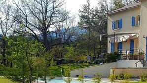 Un immeuble résidentiel doté d’une piscine, entouré de verdure et d’arbres.