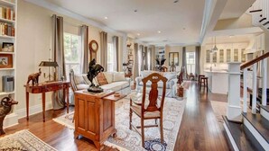 Un salon spacieux avec un grand canapé, une table basse en bois et une bibliothèque.