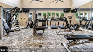 Una palestra aperta 24 ore su 24, dotata di diverse attrezzature per l'allenamento, tra cui tapis roulant, ellittiche e macchinari per pesi.