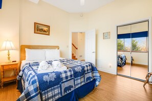 A bedroom with a bed, a nightstand, a lamp, a painting on the wall, and a sliding door leading to a balcony. - Pisgah View Cabin - Year round Mountain View  - Convenient location (Hendersonville)