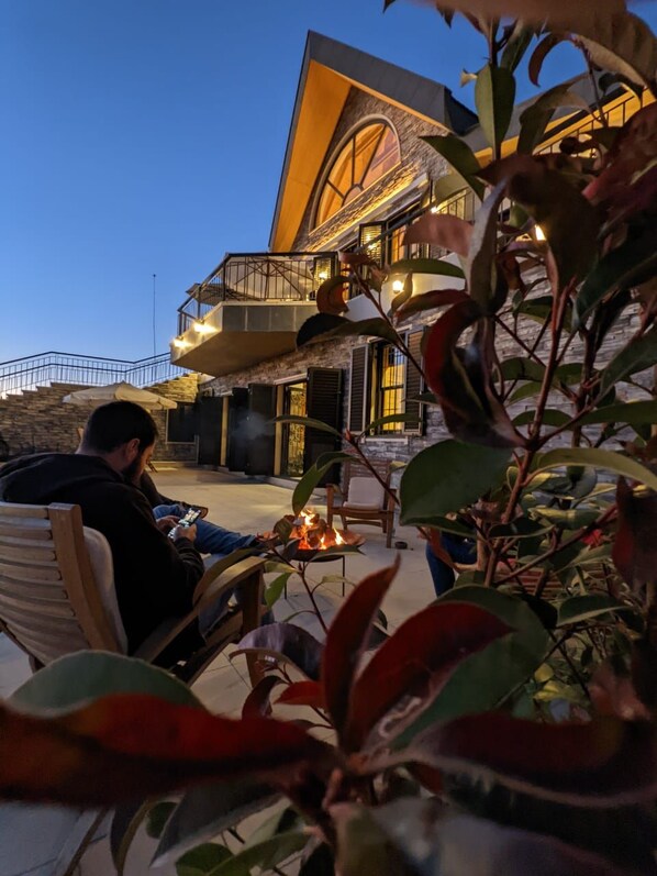 A building with a balcony and a fire feature. - Chalet de Charme (Al Arz)