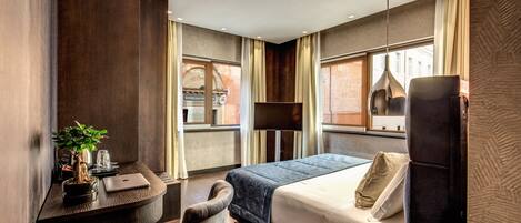 Una habitación de hotel moderna con cama, escritorio, silla y una planta en maceta.