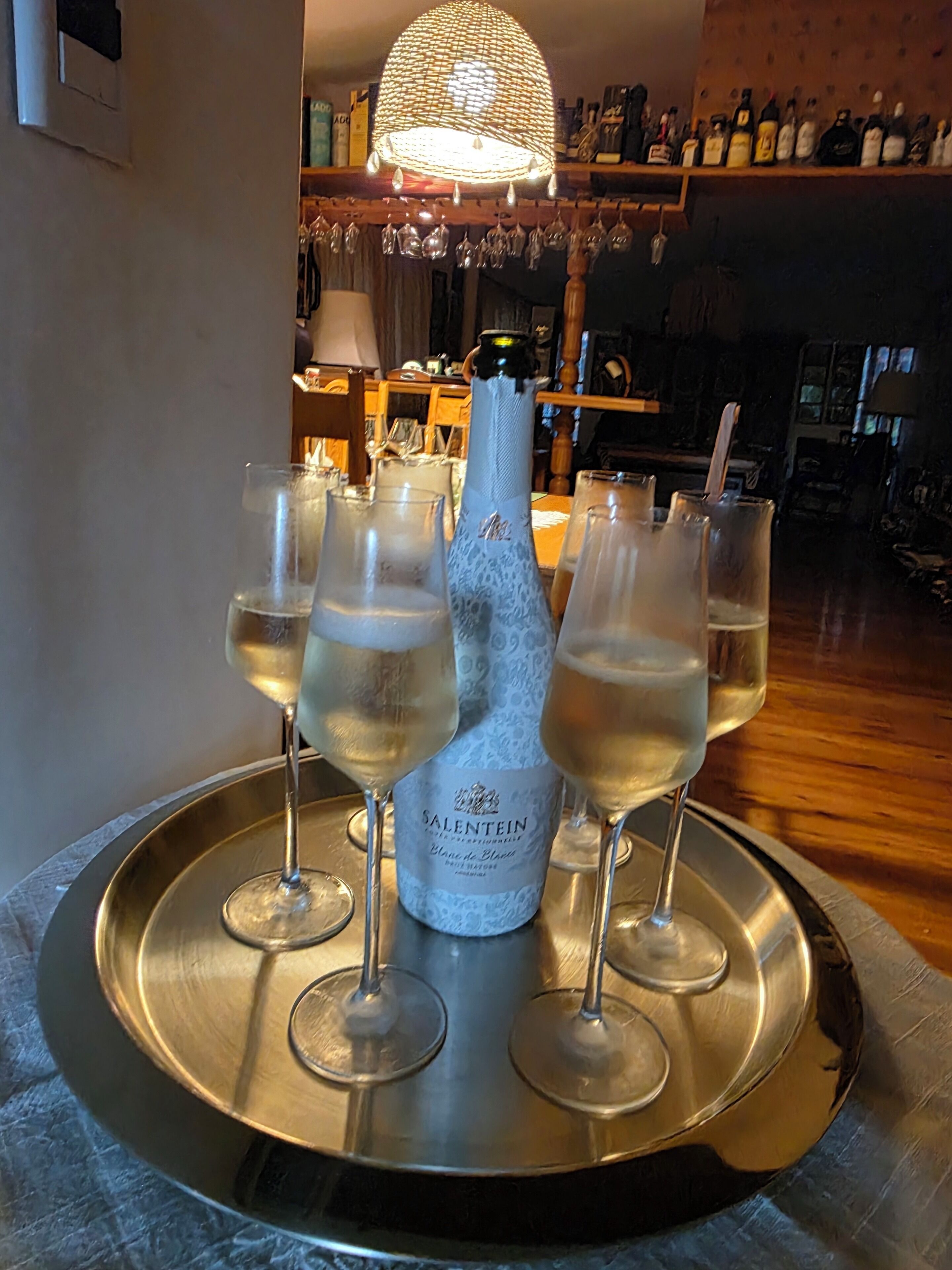 A tray with a bottle of Salentein champagne and six glasses of champagne.