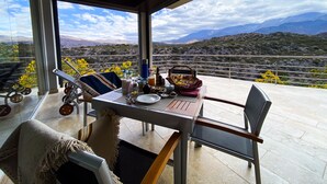 A dining area with a table set for two, overlooking a mountainous landscape. - El Carmelo Mountain Lodge (Potrerillos)
