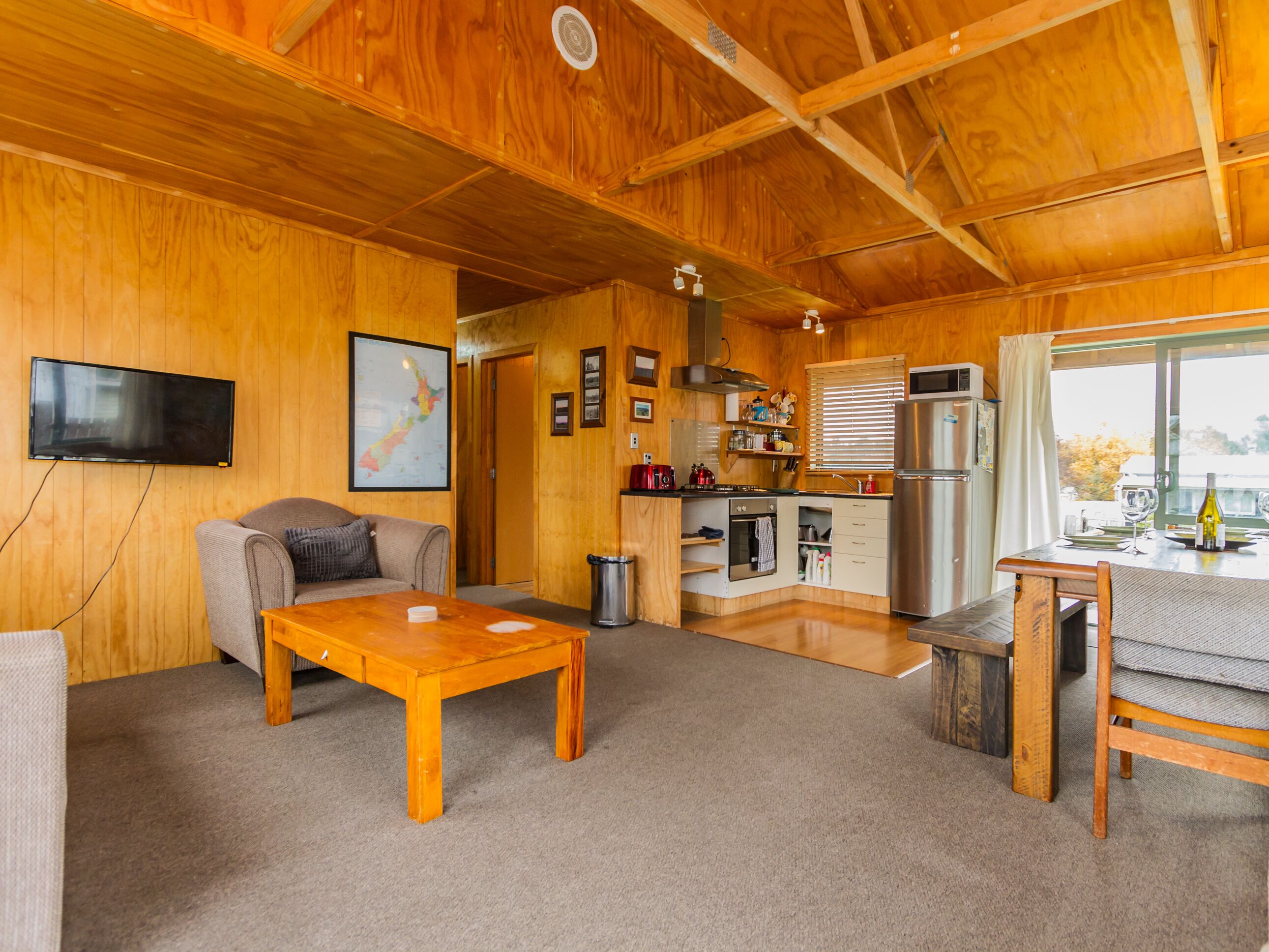A cozy wooden interior with a living room, kitchen, and dining area.