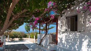 A white building with a covered outdoor seating area and a view of the sea. - Felicia s sun-side house, Cycladic house by the beach, true owner hospitality (Naxos)