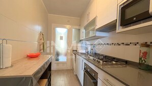 A compact kitchen with a stove, microwave, and oven.
