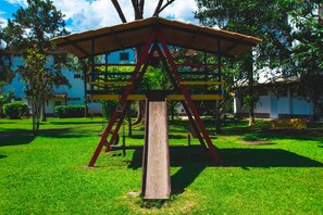 Children can play beneath the open roof of this playground structure, supported by sturdy beams.