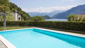 Une piscine offrant une vue dégagée sur les montagnes et un lac en arrière-plan.