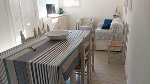 A dining area with a striped tablecloth, a white bowl, and a chair.