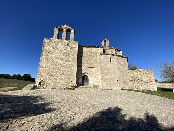 A historic stone building with a central arched entrance and two bell towers.