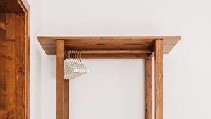 Estructura de cama de madera con colchón blanco y manta marrón.