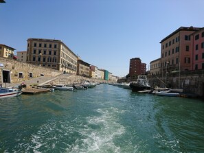Un canal bordé de bâtiments historiques, avec des bateaux amarrés de chaque côté.