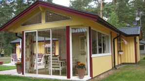 A yellow house with a red roof and a glass enclosure. - Lovely cottage in Juleboda, close to the sea with wonderful sandy beach (Degeberga)