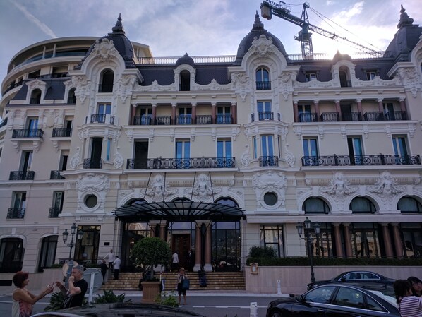 A multi-story hotel with ornate architectural details, including balconies and decorative columns.