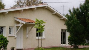 A single-story building with a flat roof, a small porch, and a front door. - Recent villa in quiet traditional neighborhood (Andernos-Les-Bains)